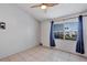 Cozy bedroom features neutral tones, tiled floors, and a ceiling fan at 2568 Woodgate Blvd # 204, Orlando, FL 32822