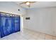 Light-filled bedroom with ceiling fan, tiled floor, and blue curtains at 2568 Woodgate Blvd # 204, Orlando, FL 32822