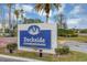 Entrance sign for Dockside Condominiums, set against a backdrop of lush landscaping at 2568 Woodgate Blvd # 204, Orlando, FL 32822