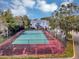 Aerial view of a community tennis court, surrounded by trees and fencing at 2568 Woodgate Blvd # 204, Orlando, FL 32822