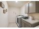 Functional laundry room with washer, dryer, and built-in storage cabinets at 307 Corsica Ct, Kissimmee, FL 34758