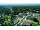 A suburban aerial view reveals a light blue home amidst lush green lawns and mature trees in a well-planned neighborhood at 311 W Delaware Ave, Lake Helen, FL 32744