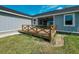 Exterior view of the backyard featuring a wooden deck and the home's light blue siding and landscaping at 311 W Delaware Ave, Lake Helen, FL 32744