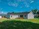 Backyard view featuring a gray home with a wooden deck and a well-maintained lawn at 311 W Delaware Ave, Lake Helen, FL 32744
