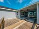 Backyard view of deck, partially covered patio, and light grey house at 311 W Delaware Ave, Lake Helen, FL 32744