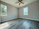 This bedroom features luxury vinyl plank flooring, a ceiling fan, and natural light from two windows at 311 W Delaware Ave, Lake Helen, FL 32744