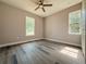Bedroom showcasing hardwood flooring, two windows, and a ceiling fan, providing natural light and ventilation at 311 W Delaware Ave, Lake Helen, FL 32744
