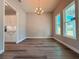 Bright dining room featuring wood floors, chandelier, and sunlit windows at 311 W Delaware Ave, Lake Helen, FL 32744