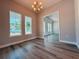 Well-lit dining room with windows, chandelier, and wood-look floors at 311 W Delaware Ave, Lake Helen, FL 32744