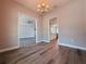 Open dining area with wood floors, decorative lighting, and easy access to the kitchen at 311 W Delaware Ave, Lake Helen, FL 32744