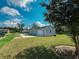 Exterior view of a gray home with a garage and a well-maintained lawn at 311 W Delaware Ave, Lake Helen, FL 32744