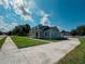 Charming blue home featuring a well-maintained lawn, long driveway and covered front porch at 311 W Delaware Ave, Lake Helen, FL 32744