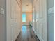 Bright hallway featuring wood-look flooring and neutral paint, leading to additional rooms with natural light at 311 W Delaware Ave, Lake Helen, FL 32744