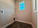 Functional laundry room featuring a storage shelf, a window, and connections for a washer and dryer at 311 W Delaware Ave, Lake Helen, FL 32744