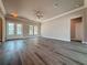Open-concept living room with wood floors, large windows, and neutral paint at 311 W Delaware Ave, Lake Helen, FL 32744