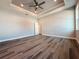 Large main bedroom with tray ceiling, ceiling fan, and abundant natural light from the expansive windows at 311 W Delaware Ave, Lake Helen, FL 32744