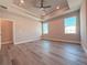 Bright main bedroom boasts a tray ceiling, ceiling fan, and multiple windows for abundant natural light at 311 W Delaware Ave, Lake Helen, FL 32744
