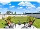 Inviting backyard patio with chairs, potted plants, and a lush lawn extending to a white fence at 312 Inman Blvd, Winter Haven, FL 33881