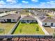 Well-maintained backyard with a verdant lawn, secure fencing, and neighborhood view, with solar panels on the roof at 312 Inman Blvd, Winter Haven, FL 33881
