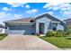 Beautiful one-story home with a well-manicured lawn, two car garage, and blue exterior at 312 Inman Blvd, Winter Haven, FL 33881