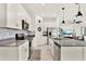 Modern kitchen with white cabinets, stainless steel appliances, gray countertops, and an island with sink at 312 Inman Blvd, Winter Haven, FL 33881