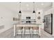 Bright kitchen features white cabinets, stainless steel appliances, gray countertops, and an island with breakfast bar at 312 Inman Blvd, Winter Haven, FL 33881