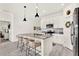 Bright kitchen features white cabinets, stainless steel appliances, gray countertops, and island with counter seating at 312 Inman Blvd, Winter Haven, FL 33881