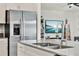 View of the kitchen island and refrigerator with stainless steel appliances and view to the living room at 312 Inman Blvd, Winter Haven, FL 33881