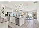 Open-concept kitchen and dining area with stainless steel appliances, island seating, and a view to the living room at 312 Inman Blvd, Winter Haven, FL 33881