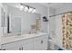 Bright bathroom with double sink vanity, large mirror, and decorative shower curtain at 3121 Buffington Pl, Oviedo, FL 32765