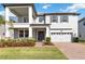 Two-story home with a covered entry, two car garage, balcony, and manicured lawn at 3121 Buffington Pl, Oviedo, FL 32765