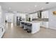 Bright, white kitchen featuring an island with seating, stainless steel appliances, and modern backsplash at 3121 Buffington Pl, Oviedo, FL 32765
