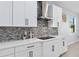 Modern kitchen with white cabinets, quartz countertops, and mosaic tile backsplash at 3121 Buffington Pl, Oviedo, FL 32765