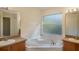 Bright bathroom with a corner soaking tub nestled between dual vanities and large mirrors at 3199 Quail Dr, Deltona, FL 32738