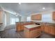Well-lit kitchen with an island, wood cabinets, and views into the adjacent living area at 3199 Quail Dr, Deltona, FL 32738
