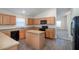 Efficient kitchen featuring an island, wood-look flooring, ample countertop space, and modern appliances at 3199 Quail Dr, Deltona, FL 32738