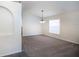 Bright, carpeted living room featuring a modern chandelier and large window for ample natural light at 3199 Quail Dr, Deltona, FL 32738