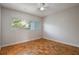 Bright bedroom featuring wood floors, ceiling fan, and a window providing natural light at 3214 Debbie Dr, Orlando, FL 32806