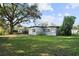 Backyard view showing the home's exterior with large tree at 3214 Debbie Dr, Orlando, FL 32806