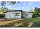 Exterior side view of the home with gray block and grassy yard at 3214 Debbie Dr, Orlando, FL 32806