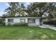 Charming single-story home featuring a well-maintained lawn and a covered carport with decorative iron supports at 3214 Debbie Dr, Orlando, FL 32806