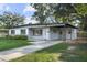Welcoming single-story home with a lush green lawn and a convenient covered carport, providing ample parking at 3214 Debbie Dr, Orlando, FL 32806