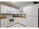 Well-lit kitchen with white appliances and cabinetry, offering ample counter space and storage options at 3214 Debbie Dr, Orlando, FL 32806