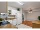 Clean kitchen with white appliances and cabinetry, seamlessly flowing into a dining area with hardwood flooring at 3214 Debbie Dr, Orlando, FL 32806