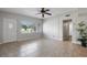 Bright living room with neutral tile flooring, a ceiling fan, and a large window offering natural light at 3214 Debbie Dr, Orlando, FL 32806