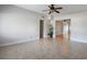 Open-concept living space with neutral tile flooring, a ceiling fan, and seamless transition to adjacent rooms at 3214 Debbie Dr, Orlando, FL 32806