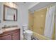 Bathroom features a marble sink with wooden cabinet, toilet, and a yellow shower-tub combo at 397 Oslo Dr, Deltona, FL 32725