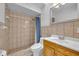 A bathroom features tiled shower, toilet, a sink with wood cabinet, and a mirror at 397 Oslo Dr, Deltona, FL 32725