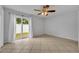 A bedroom features tile flooring, a ceiling fan, and sliding glass doors to the backyard at 397 Oslo Dr, Deltona, FL 32725
