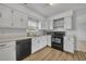 A kitchen features white cabinets, countertops, wood-look flooring, and black appliances at 397 Oslo Dr, Deltona, FL 32725